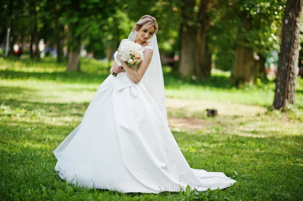 Linda novia rubia con ramo de boda en el parque en el día soleado . — Foto de Stock