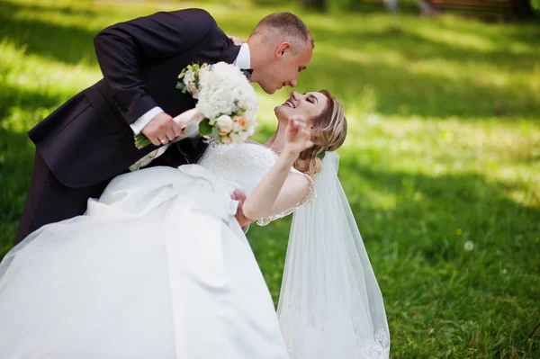 Abbracci di coppia nuziali alla moda a parco verde su matrimonio soleggiato — Foto Stock