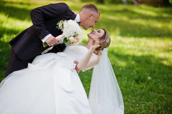 Fashionable wedding couple hugging at green park on sunny weddin — Stock Photo, Image