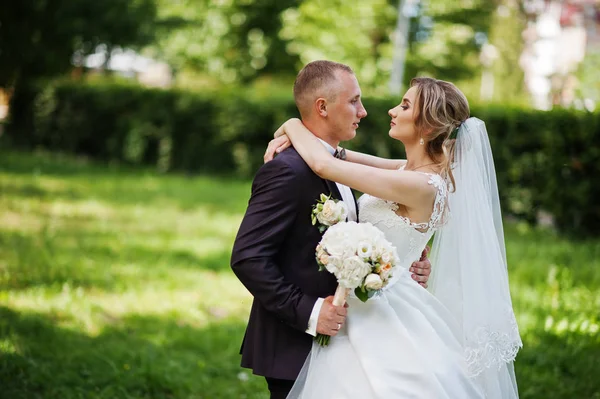 Fashionabla bröllopsparet kramas på gröna park på soliga bröll — Stockfoto