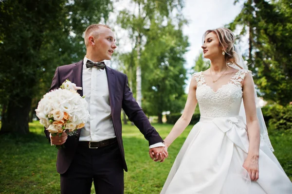 Fashionable wedding couple hugging at green park on sunny weddin — Stock Photo, Image