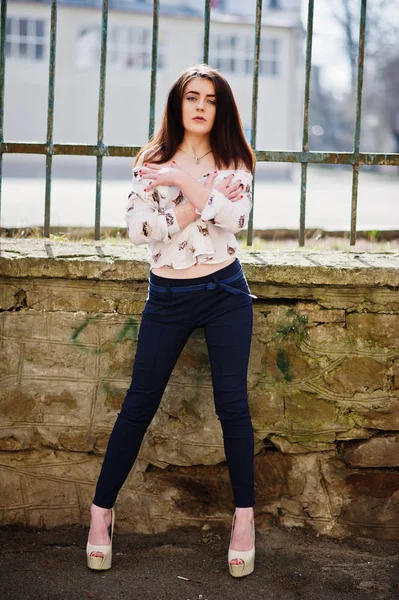 Jonge stijlvolle brunette meisje op shirt, broek en hoge hakken schoenen — Stockfoto