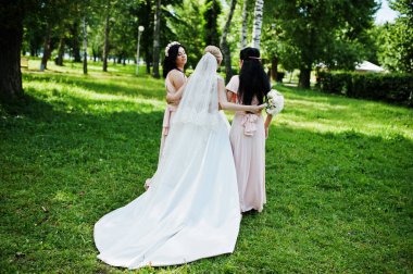 Gelin park pembe d üzerinde iki şirin esmer nedime ile poz verdi