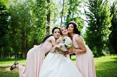 Gelin park pembe d üzerinde iki şirin esmer nedime ile poz verdi
