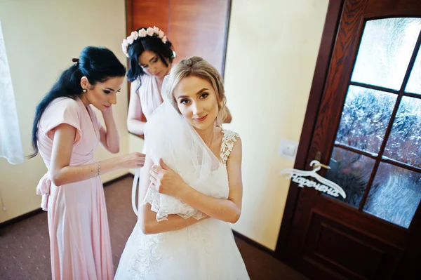 Модные подружки невесты на розовых платьях помогали носить бант на спине — стоковое фото