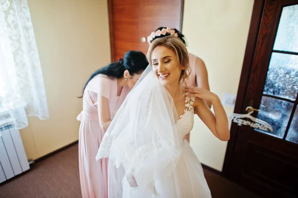 Модні подружки наречених на рожевих сукнях допомогли носити лук на спині — стокове фото