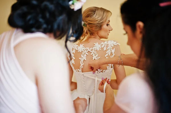 Modieuze bruidsmeisjes op roze jurken hielp slijtage strik op de rug — Stockfoto