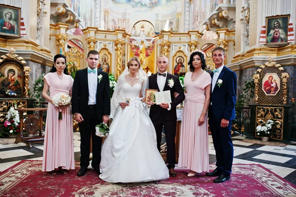 Hochzeitspaar mit Brautjungfern und Trauzeugen in der Kirche. — Stockfoto