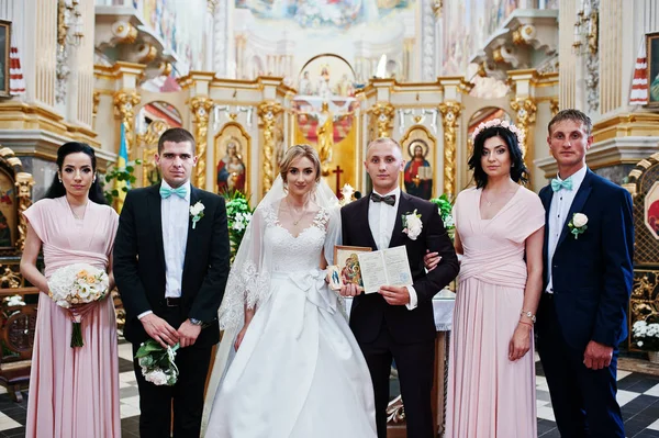Hochzeitspaar mit Brautjungfern und Trauzeugen in der Kirche. — Stockfoto