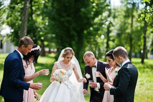 Esküvői pár ujjongott pezsgőspoharak, koszorúslányok és a b — Stock Fotó
