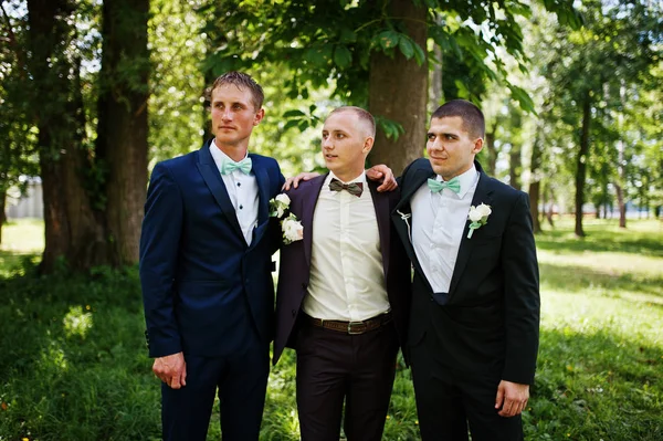 Groom with his best man\'s on wedding at park.