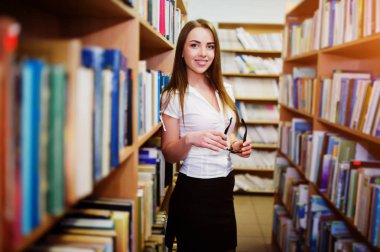 Kütüphane yandan, gözlüklü esmer kız giymek beyaz blo