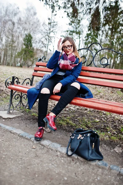 Young girl smoking cigarette outdoors sitting on bench. Concept — Stock Photo, Image