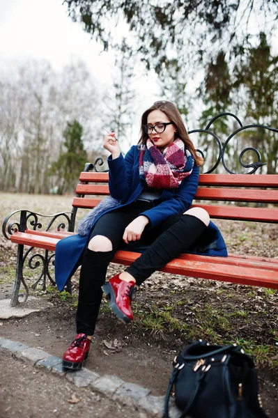 Menina fumando cigarro ao ar livre sentado no banco. Conceito — Fotografia de Stock