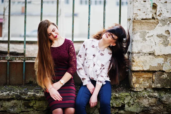 Dos jóvenes adolescentes sentados contra la cerca de hierro y en movimiento wi — Foto de Stock