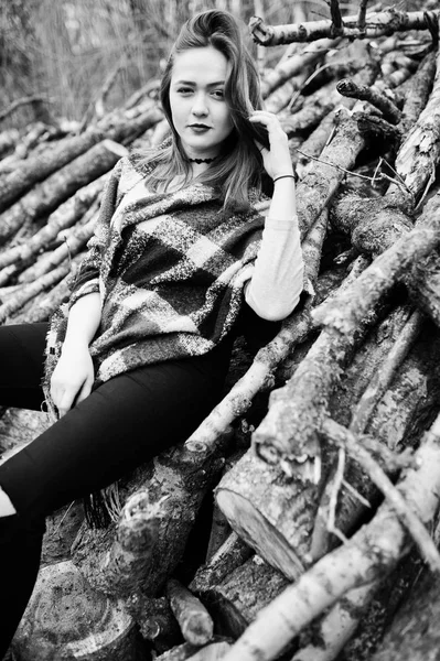 Νέοι hipster κορίτσι φθορά σε κουβέρτα εναντίον ξύλινα κούτσουρα σε ξύλο — Φωτογραφία Αρχείου