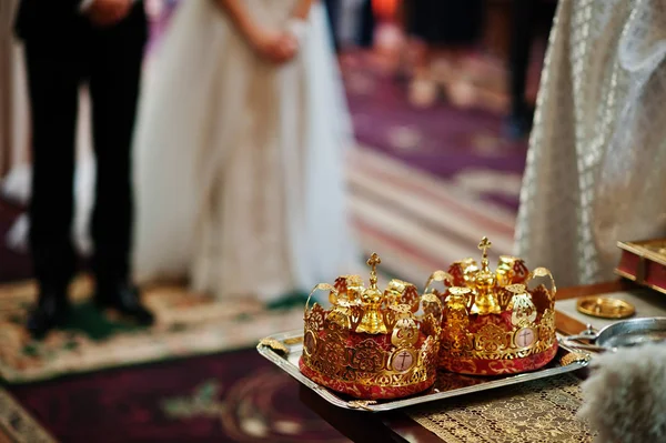 Coronas de boda doradas en la mesa en la iglesia . —  Fotos de Stock