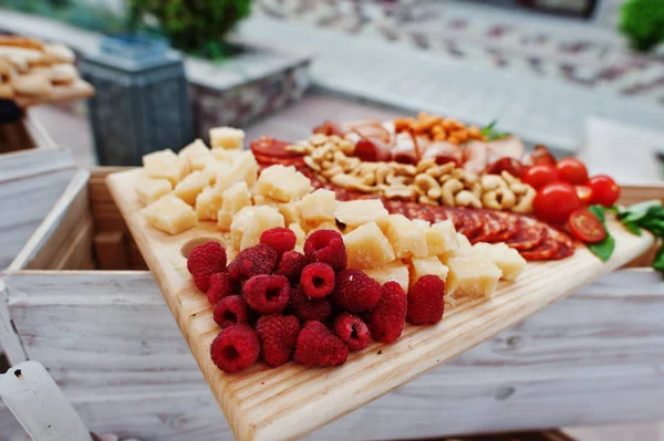 Frambuesa, queso y diferentes nueces en tablero de madera en la boda —  Fotos de Stock
