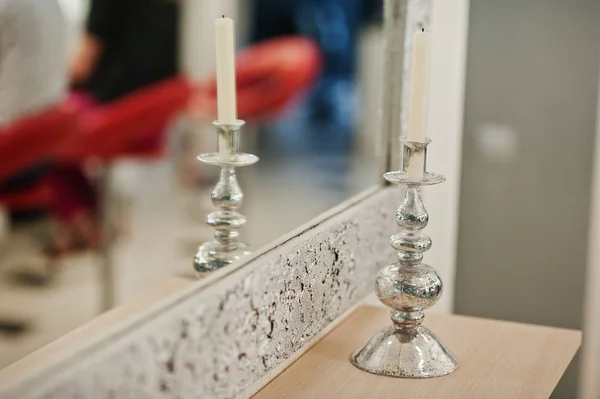 Ljus på silver ljusstake på skönhetssalongen mot spegel. — Stockfoto