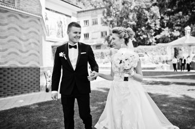 Şık Düğün çifti aşık yeşil çimenlerin üzerinde yürüyüş.