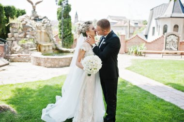 Şık Düğün çifti aşık yeşil çimenlerin üzerinde yürüyüş.