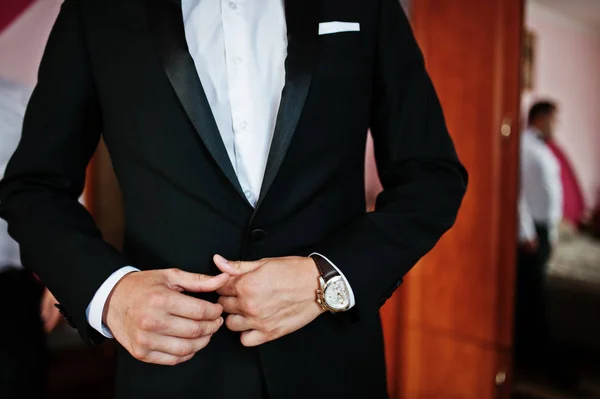 Händer på tuxedo eleganta brudgummen in i rummet på bröllop Godmorgon — Stockfoto