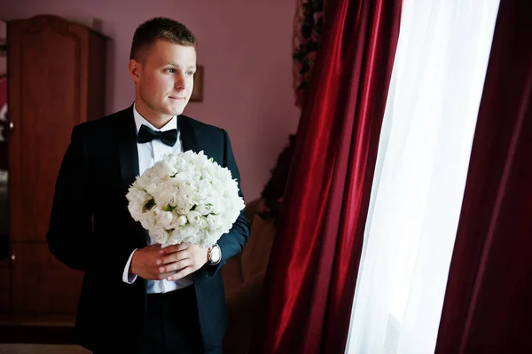 Стильний наречений з весільним букетом біля його кімнати . — стокове фото