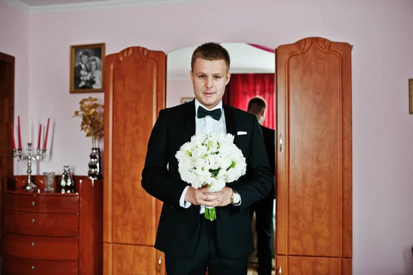Elegáns vőlegény, esküvői csokor, a kezét a szobájába. — Stock Fotó