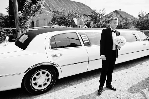 Mariage élégant avec bouquet de mariage aux mains près de la limousine . — Photo