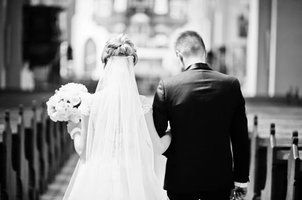 Fotosessão de casal de casamento elegante na igreja católica . — Fotografia de Stock