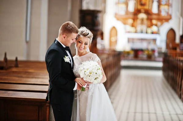 Fotosessão de casal de casamento elegante na igreja católica . — Fotografia de Stock