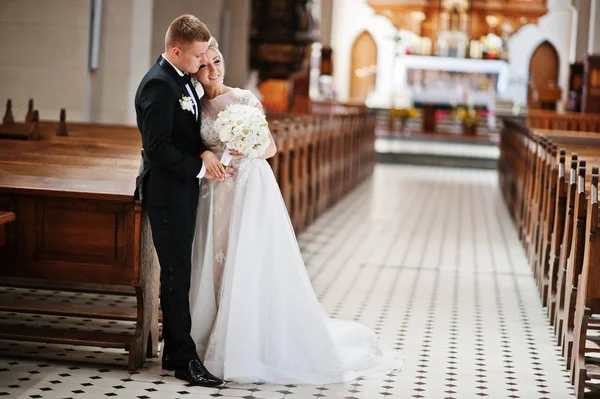 Fotosession av eleganta bröllop par på katolska kyrkan. — Stockfoto