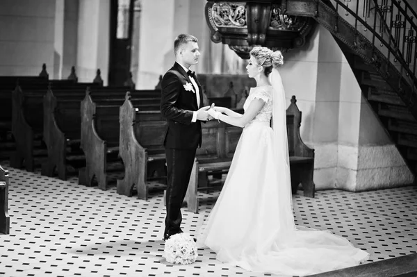 Fotosessão de casal de casamento elegante na igreja católica . — Fotografia de Stock