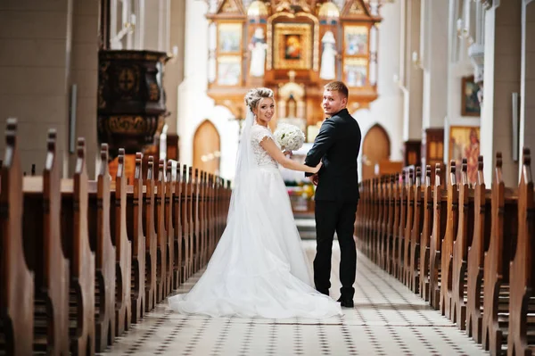 Fotosessão de casal de casamento elegante na igreja católica . — Fotografia de Stock