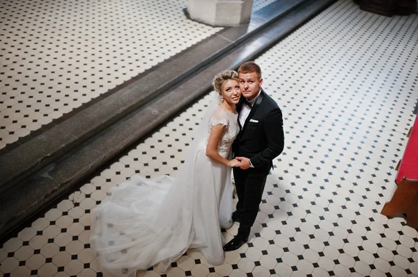 Fotosessão de casal de casamento elegante na igreja católica . — Fotografia de Stock