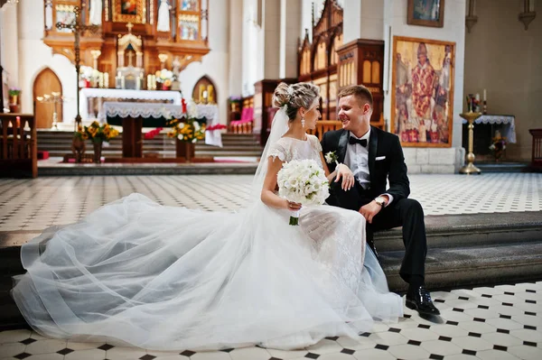 Fotosession av eleganta bröllop par på katolska kyrkan. — Stockfoto