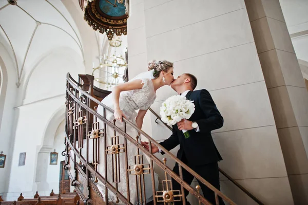 Fotosession av eleganta bröllop par på katolska kyrkan. — Stockfoto