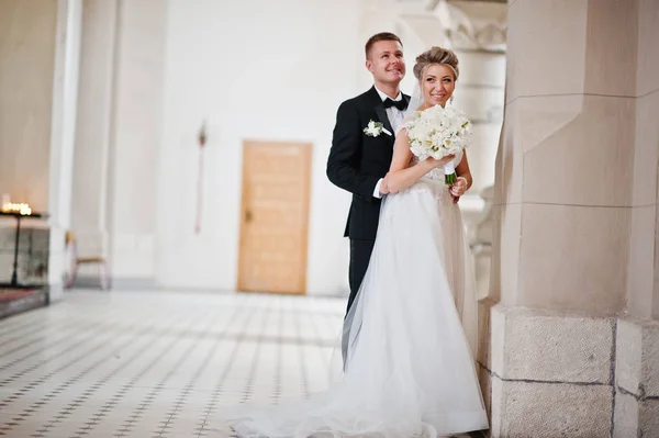 Fotosessão de casal de casamento elegante na igreja católica . — Fotografia de Stock