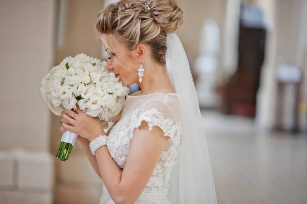 Noiva loira com buquê de casamento às mãos na igreja católica . — Fotografia de Stock