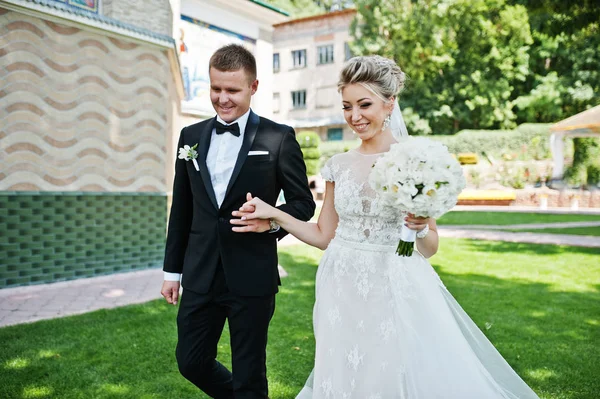 Elegante coppia di nozze che cammina in amore sul prato verde . — Foto Stock