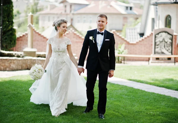 Elegante coppia di nozze che cammina in amore sul prato verde . — Foto Stock