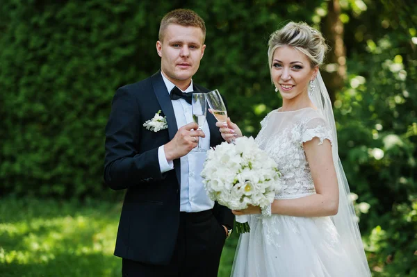 シャンパンのグラスとスタイリッシュで豪華な結婚式のカップル. — ストック写真
