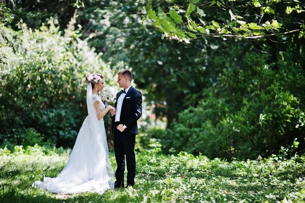 Stijlvolle en prachtige bruidspaar wandelen buiten in het park op s — Stockfoto