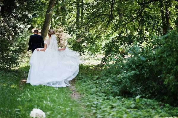 Casal de casamento elegante e lindo andando ao ar livre no parque em s — Fotografia de Stock