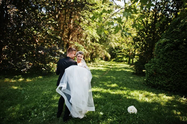 Casal de casamento elegante e lindo andando ao ar livre no parque em s — Fotografia de Stock