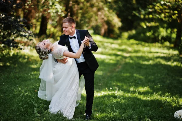 Stylish and gorgeous wedding couple walking outdoor at park on s — Stock Photo, Image