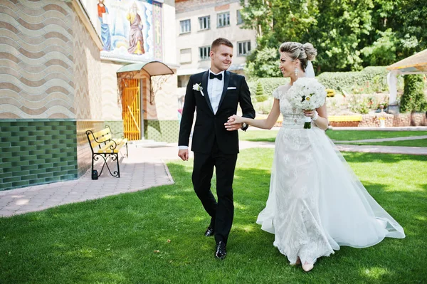 Κομψό γαμήλιο ζεύγος περπάτημα στην αγάπη στο πράσινο γκαζόν. — Φωτογραφία Αρχείου