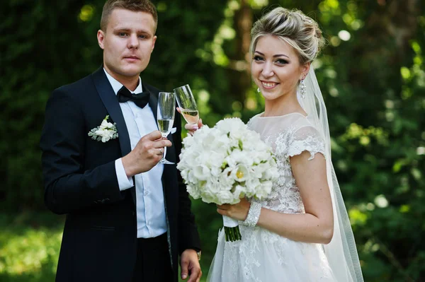 Snygga och vackra bröllopsparet med glas champagne. — Stockfoto