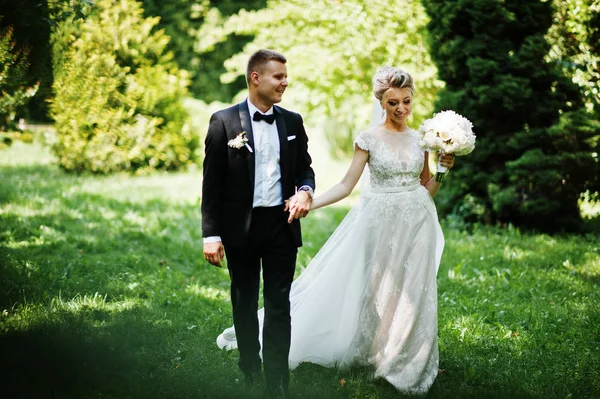 Élégant et magnifique couple de mariage marchant en plein air au parc sur s — Photo