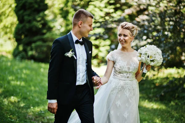 Élégant et magnifique couple de mariage marchant en plein air au parc sur s — Photo